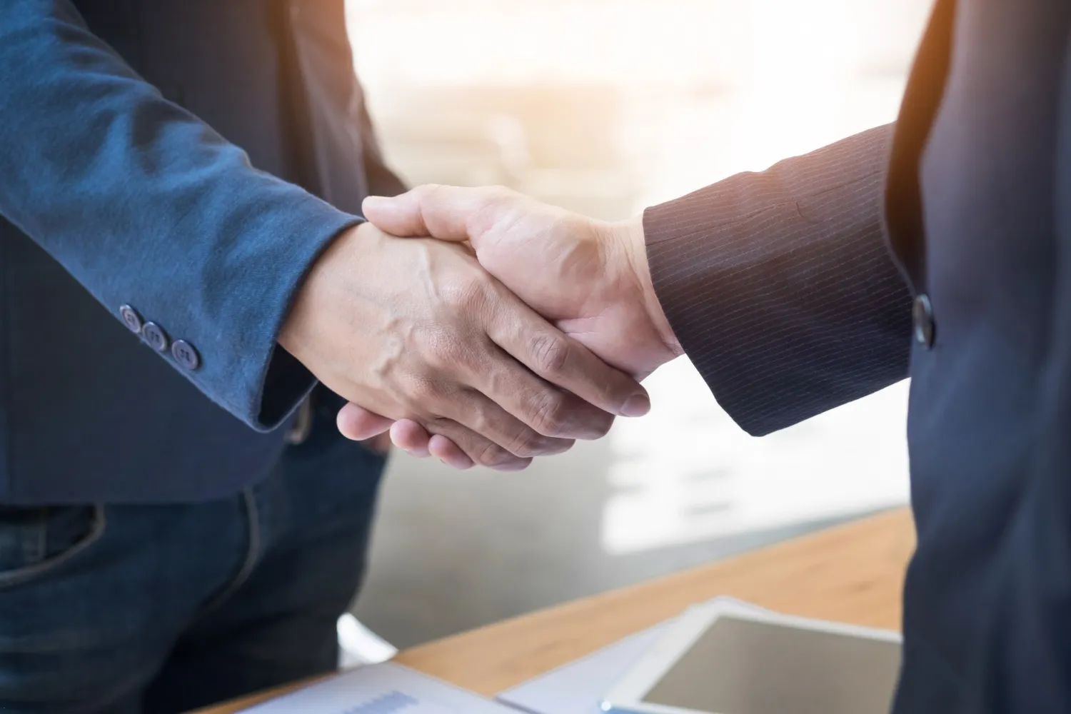 Two confident business man shaking hands during a meeting in the office Two confident business man shaking hands during a meeting in the office